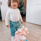 Toddler smiling with pink dinosaur plushy soft toy unique baby gift