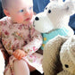 Baby girl looking at Teddy bear soft toy, handmade baby gift made in Ireland Wonky Woolins. Unique baby gift